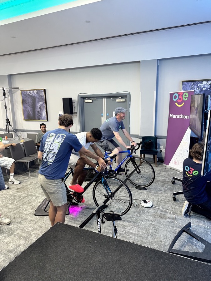 Participants riding static bikes at an o3e charity marathon